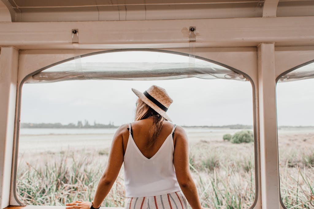 Back View of a Woman Standing and Looking at Field in Summer