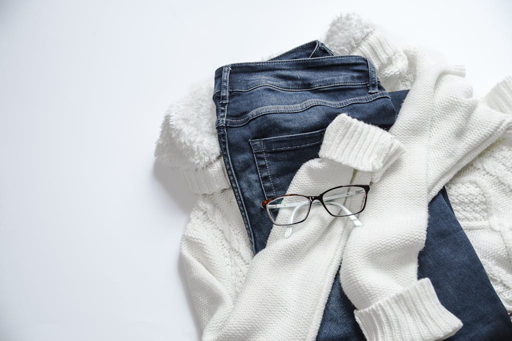 Black Framed Eyeglasses layering On White Jacket And Blue Denim Bottoms