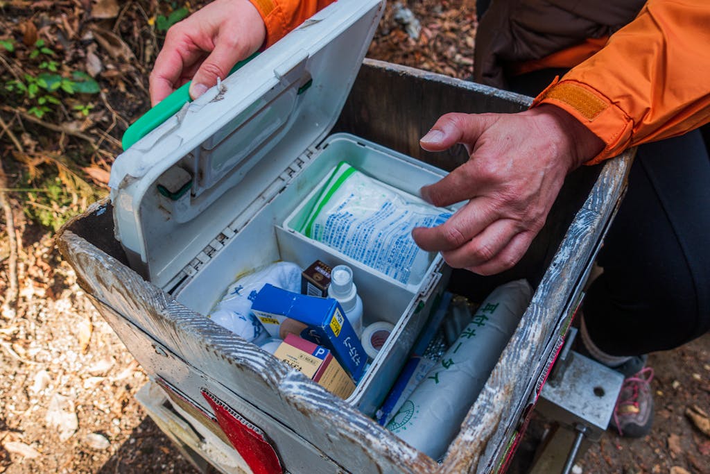 a person opening a box with a first aid kit