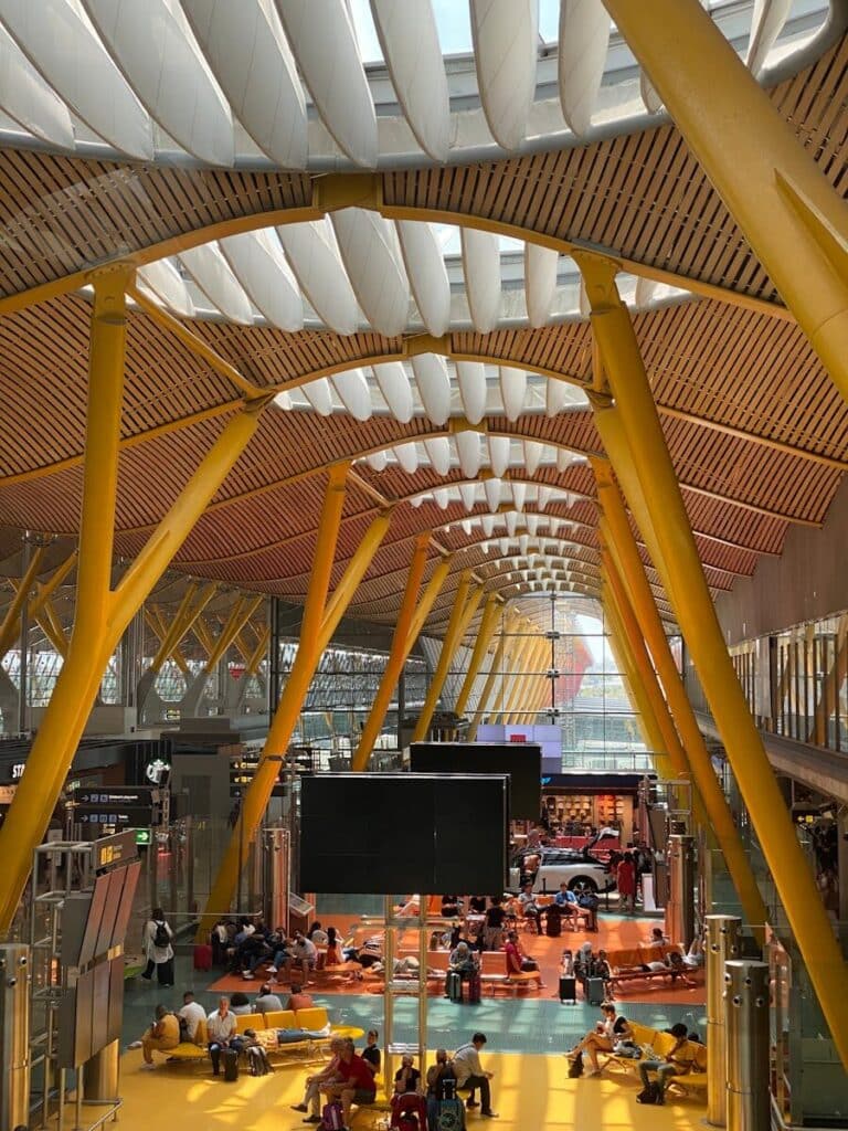 Madrid airport terminal interior with travellers waiting in arrivals hall