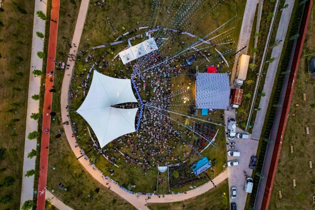 Aerial view of fan zone crowd gathered around stage and screens