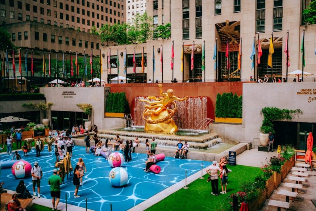 Top Things to Do in New York City During the World Cup 2026 3 Visitors enjoying Rockefeller Center plaza with Prometheus statue and fan activities in Manhattan