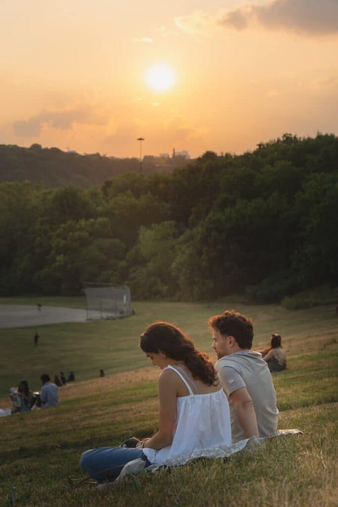 People relaxing on the grass at sunset on Toronto Islands with a peaceful atmosphere