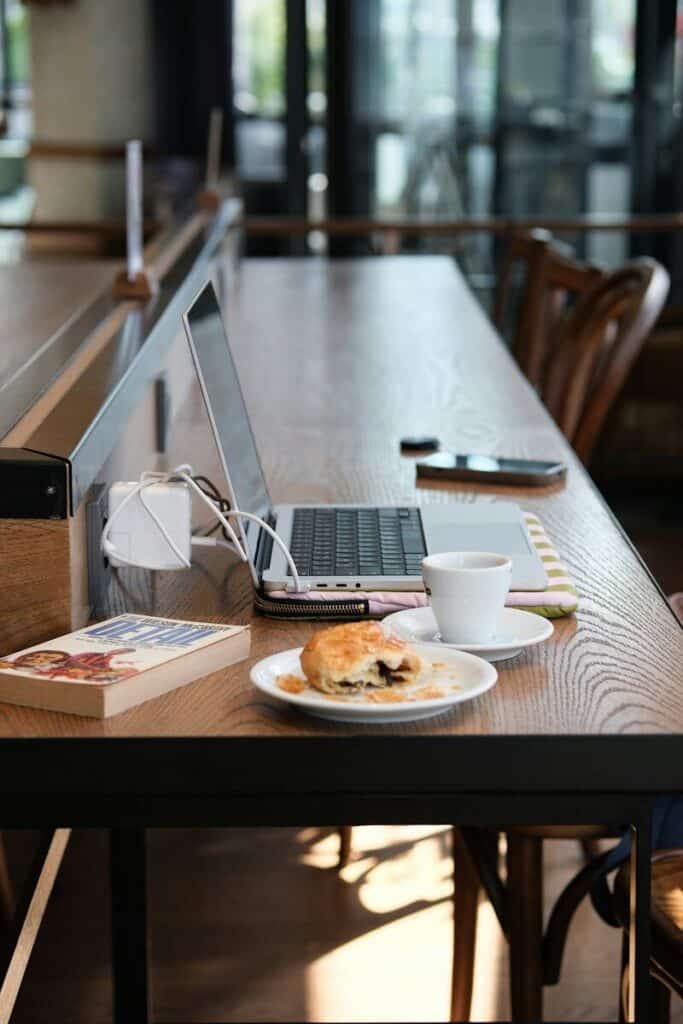 Laptop and coffee on table in cafe with WiFi setup