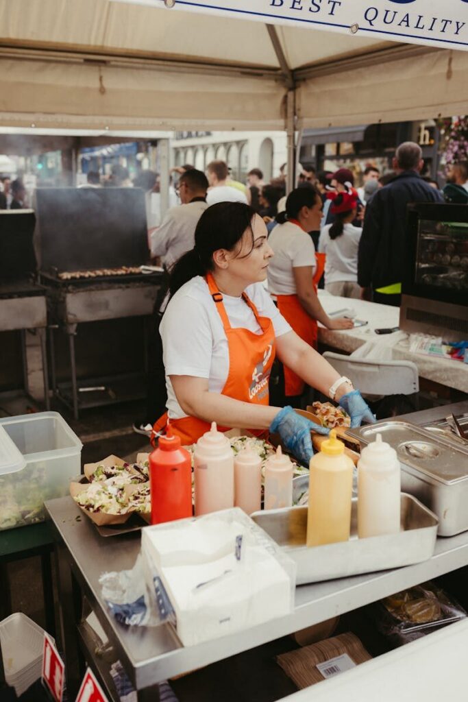 Street food vendor preparing meals at a busy fan zone food market