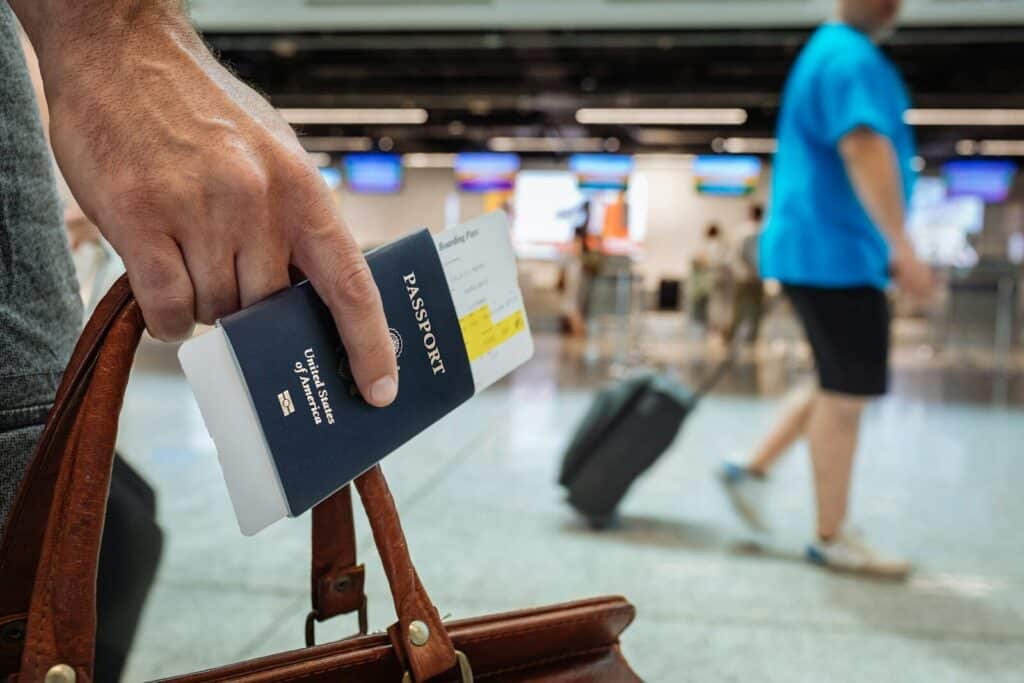 World Cup 2026 Travel Tips: What Most Guides Won't Tell You 7 Traveler holding passport and boarding pass at airport terminal