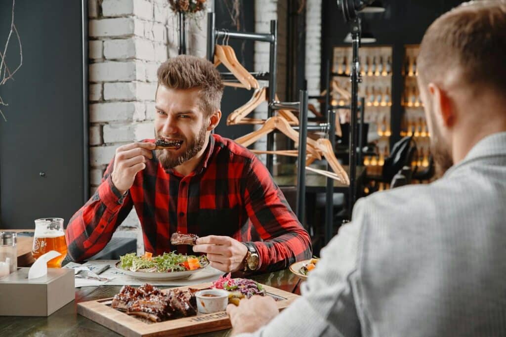 Top Things to Do in Dallas During the World Cup 2026 17 People eating BBQ at a restaurant table in Dallas with brisket and side dishes