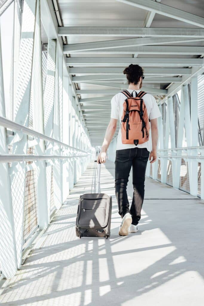 Traveler walking with carry-on suitcase and backpack, ideal for packing light for the World Cup 2026Traveling with carry-on only