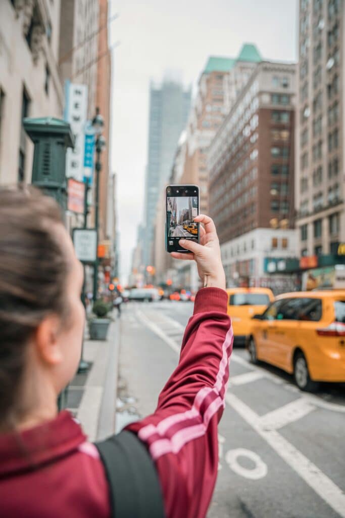 Traveler using a smartphone to capture and share moments in a busy city like New York