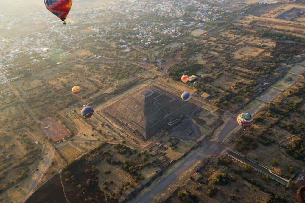 Aerial view of Teotihuacán with the Pyramid of the Sun and hot air balloons at sunrise