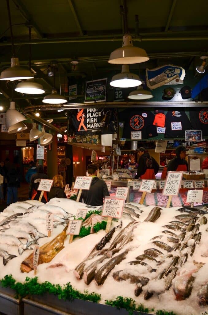 Fresh fish display at Pike Place Market with vendors and visitors in Seattle