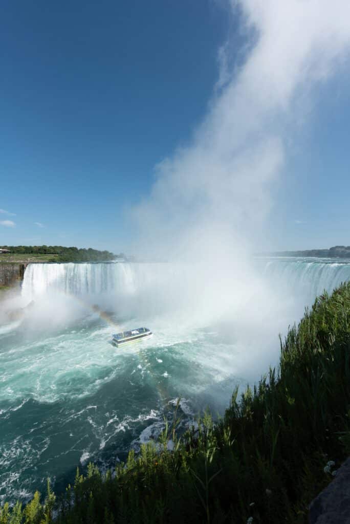 Boat approaching Niagara Falls surrounded by mist and powerful waterfalls