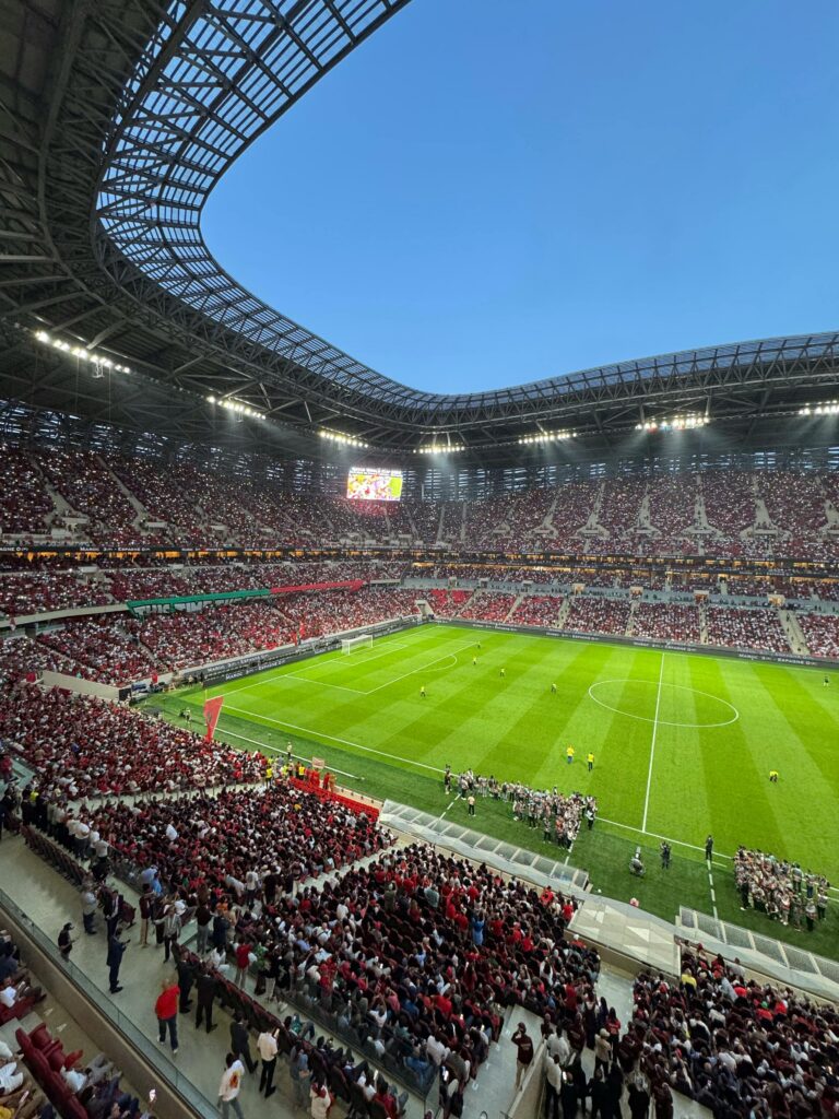 Large football stadium filled with fans during an international match, where mobile networks often become overloaded