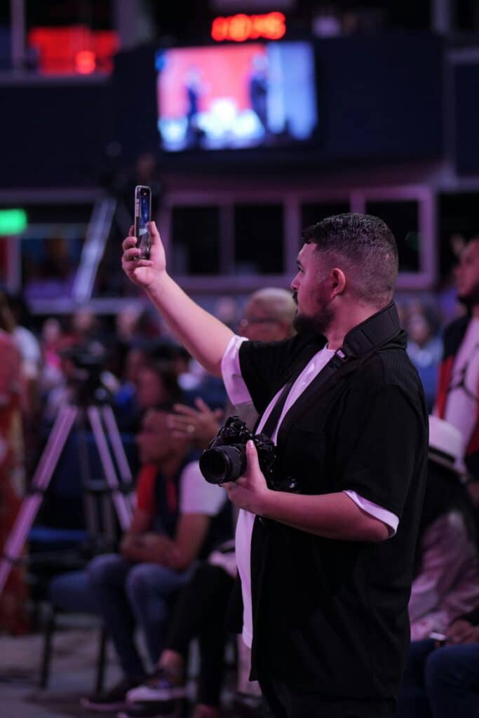 Football fan recording video on smartphone inside crowded stadium, where mobile data speeds are often limited