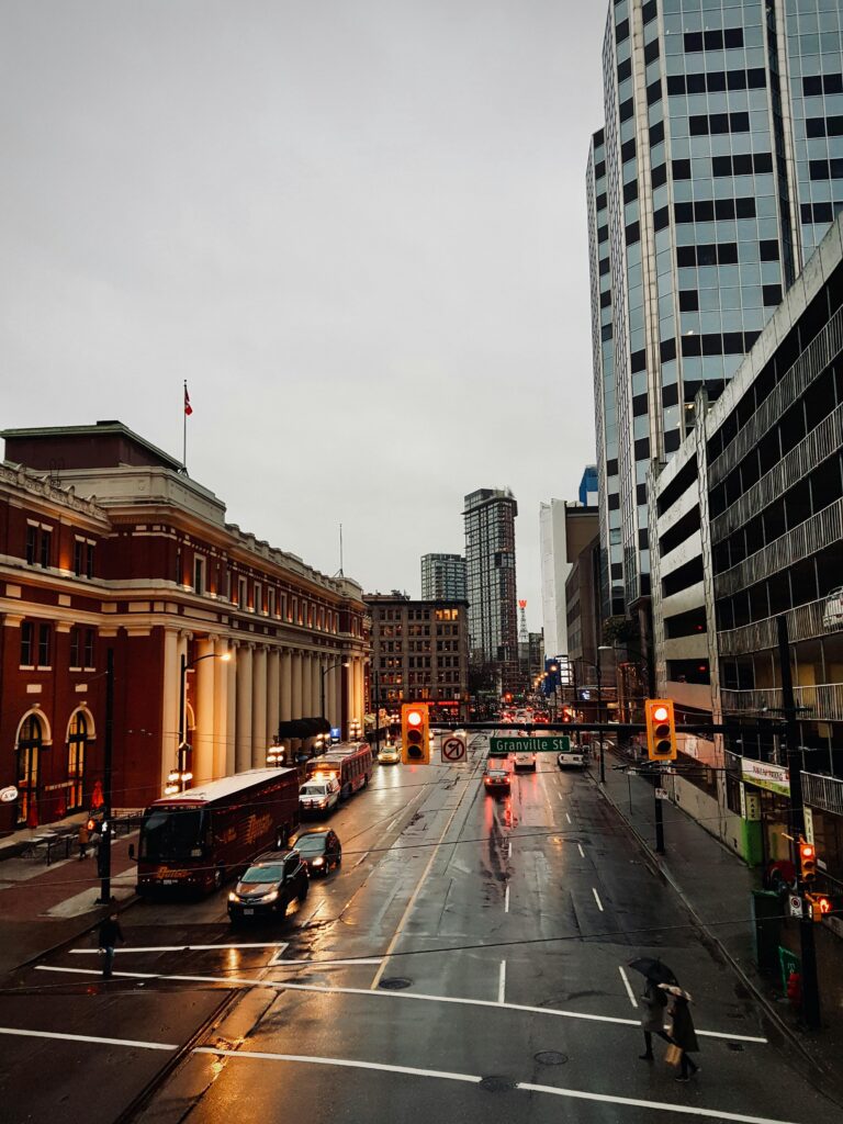 Rainy street on Granville Street in Vancouver with traffic, pedestrians, and wet roads reflecting city lights