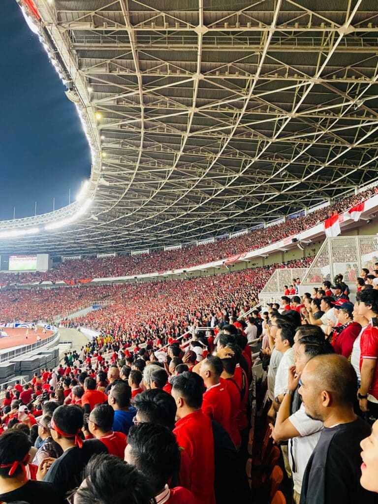 Packed football stadium with thousands of fans watching a live match from the stands