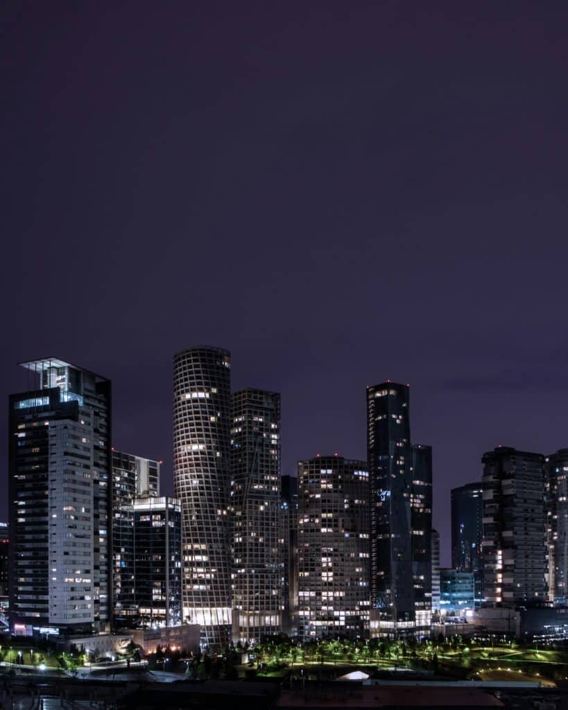 Modern city skyline at night with illuminated buildings, representing World Cup host cities in Mexico