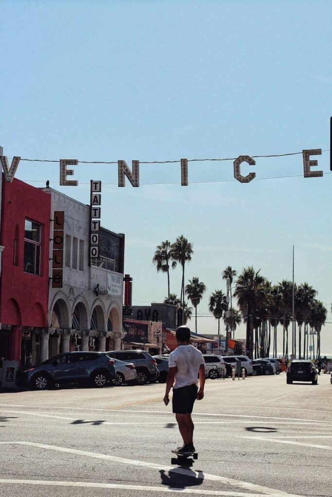 Venice Beach boardwalk with skater under the Venice sign in Los Angeles