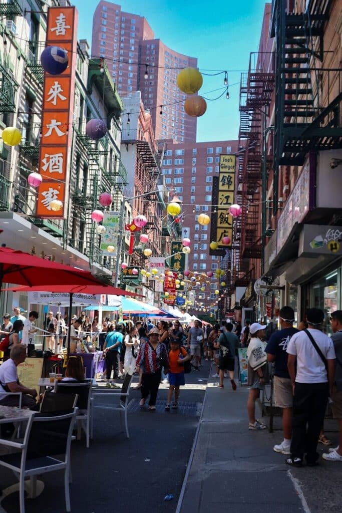 Top Things to Do in New York City During the World Cup 2026 13 Busy street in Chinatown New York with restaurants, lanterns, and people dining outdoors