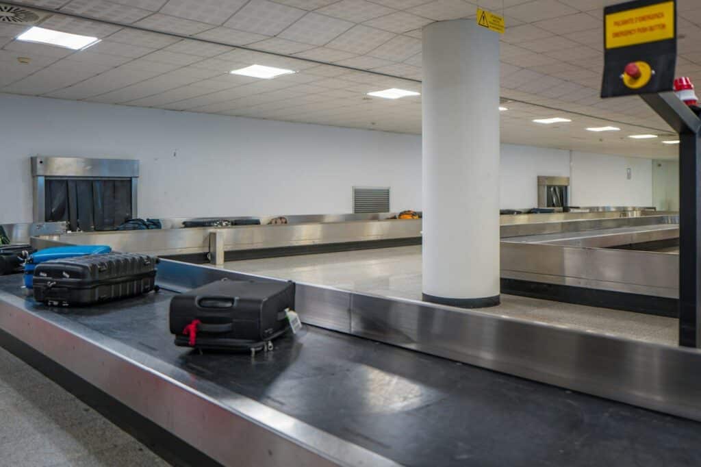 How to Plan a Last-Minute World Cup 2026 Trip (8-Week Countdown) 12 Suitcase on airport baggage claim conveyor belt during travel