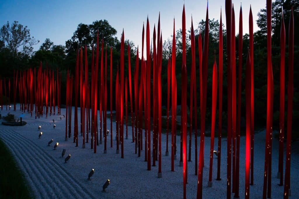 Chihuly Garden and Glass outdoor installation with illuminated red glass sculptures at dusk