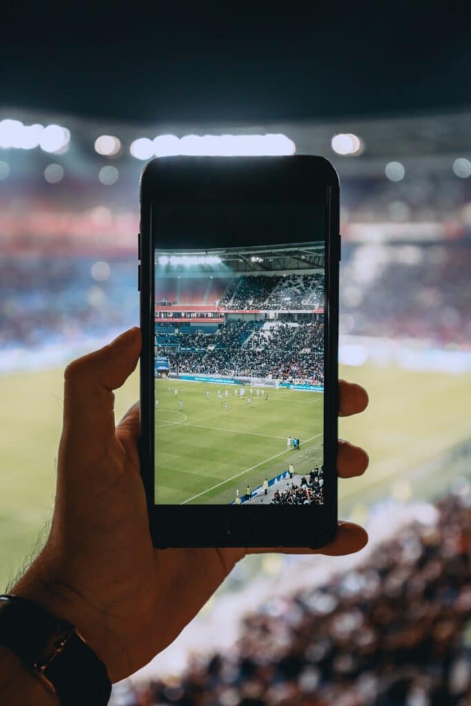 How Much Mobile Data Do You Need at the FIFA World Cup 2026? (Without Overpaying) 3 Watching football match highlights on smartphone inside stadium — mobile streaming during live events