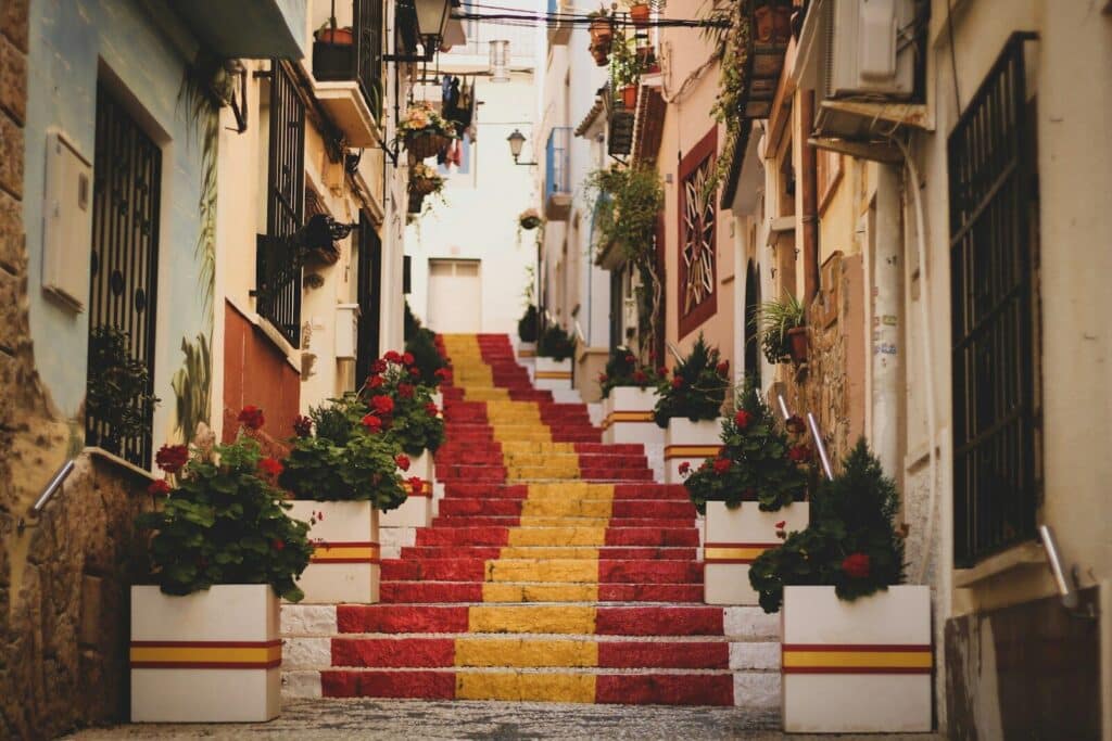 Colorful street with Spanish flag-painted stairs in a traditional village in Spain — Do You Need an eSIM for Spain?