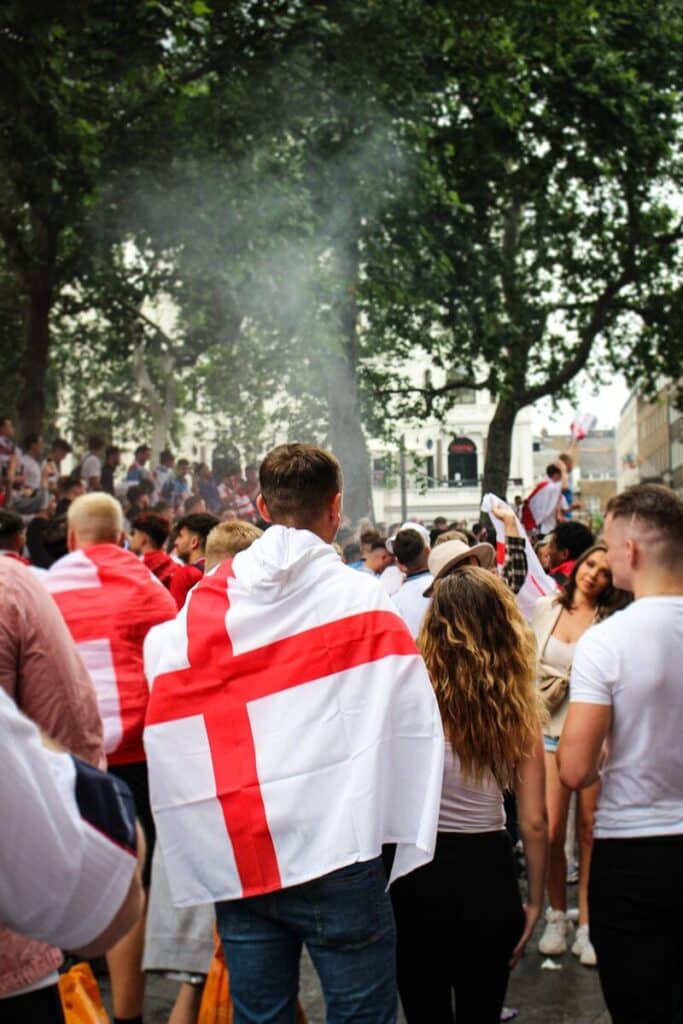 Football fans wearing flags walking toward a fan zone event