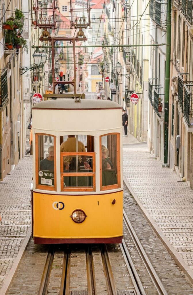 eSIM Portugal vs Roaming: Best Way to Stay Connected as a Traveler in 2026 2 eSIM Portugal yellow tram climbing a narrow cobblestone street in Lisbon