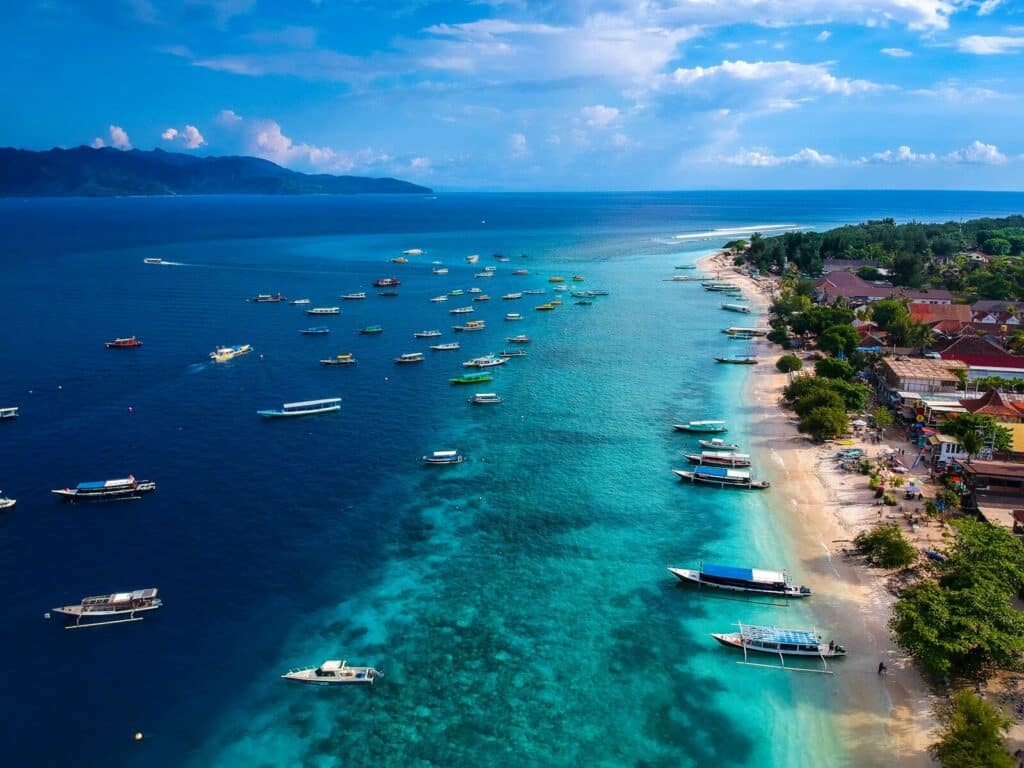 aerial view of Lombok coastline with dozens of colourful boats anchored in turquoise water