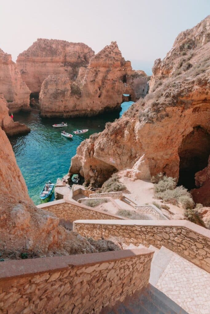 eSIM Portugal vs Roaming: Best Way to Stay Connected as a Traveler in 2026 1 rocky Algarve coastline with turquoise water and stone steps leading down to the sea