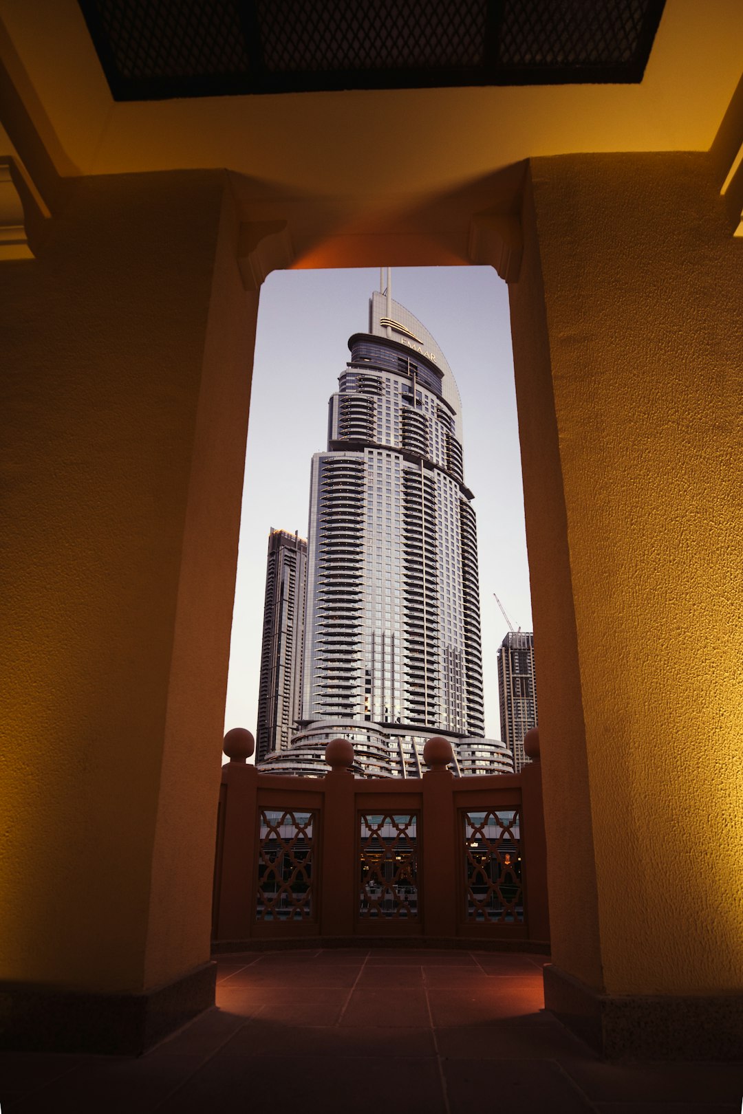Tall building towering over Dubai next to a bridge