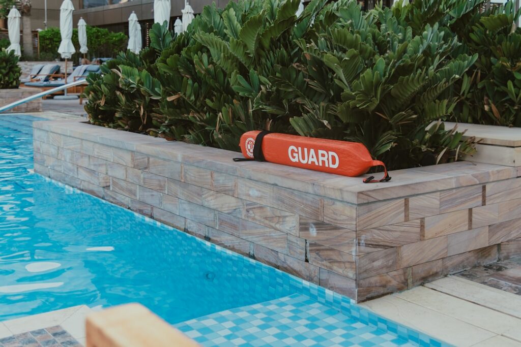 Hotel pool with a guard sign, part of weighing is dubai worth visiting summer