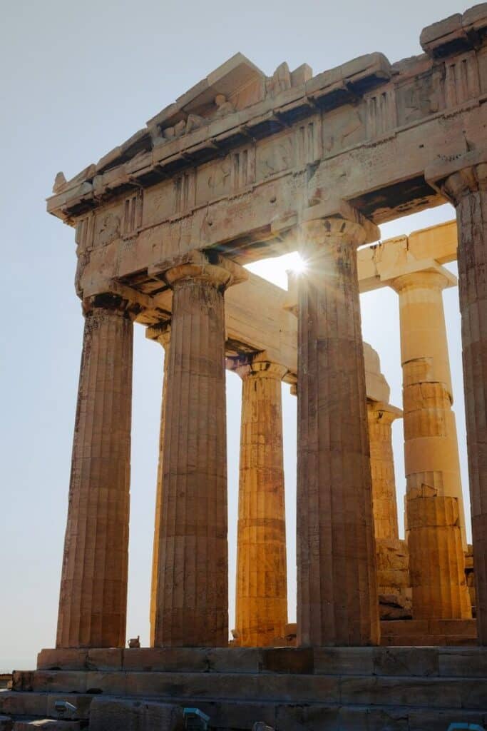 Parthenon columns on the Acropolis in Athens with sunlight breaking through at golden hour