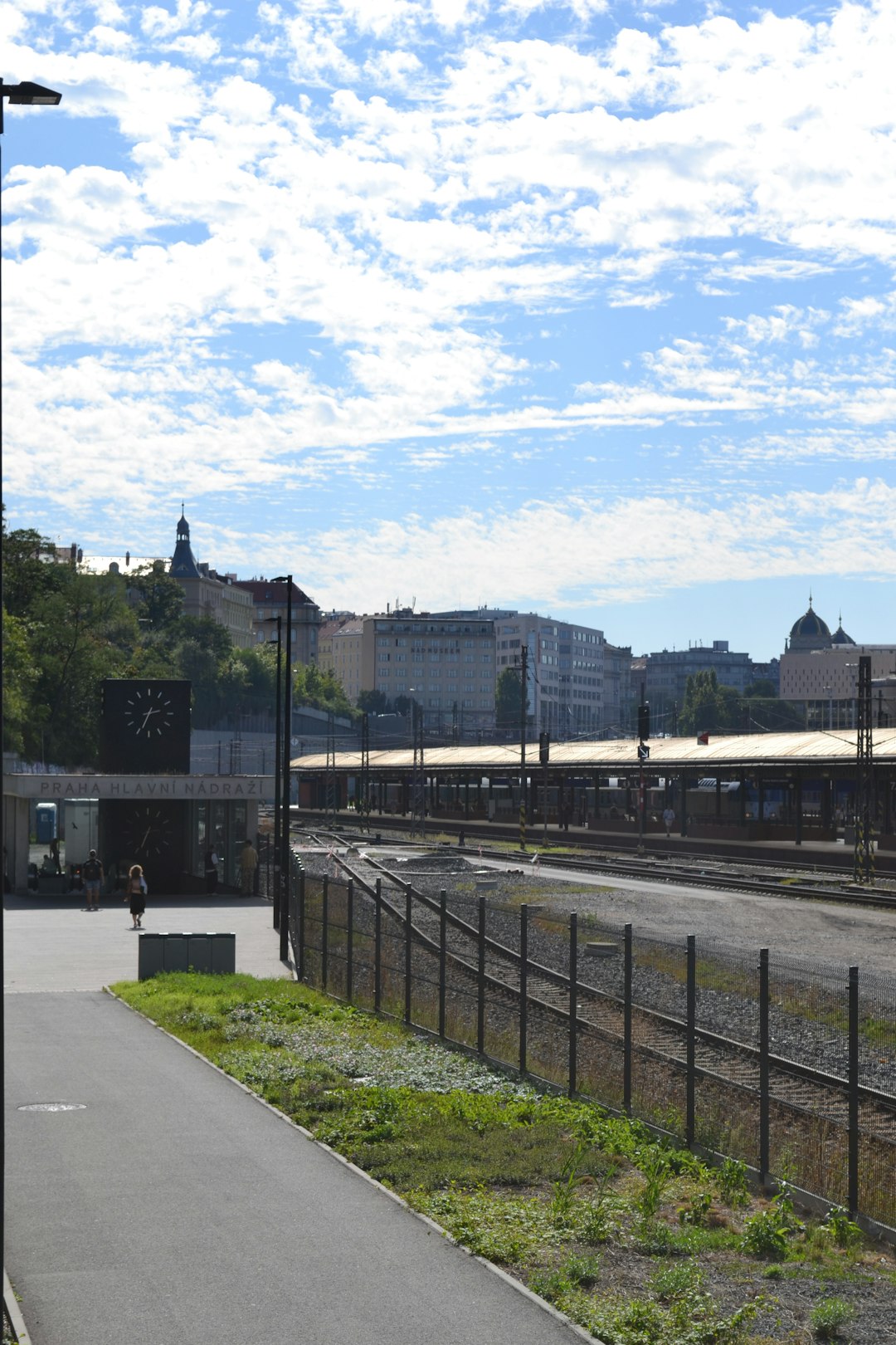 Train station platform with city buildings under a cloudy sky