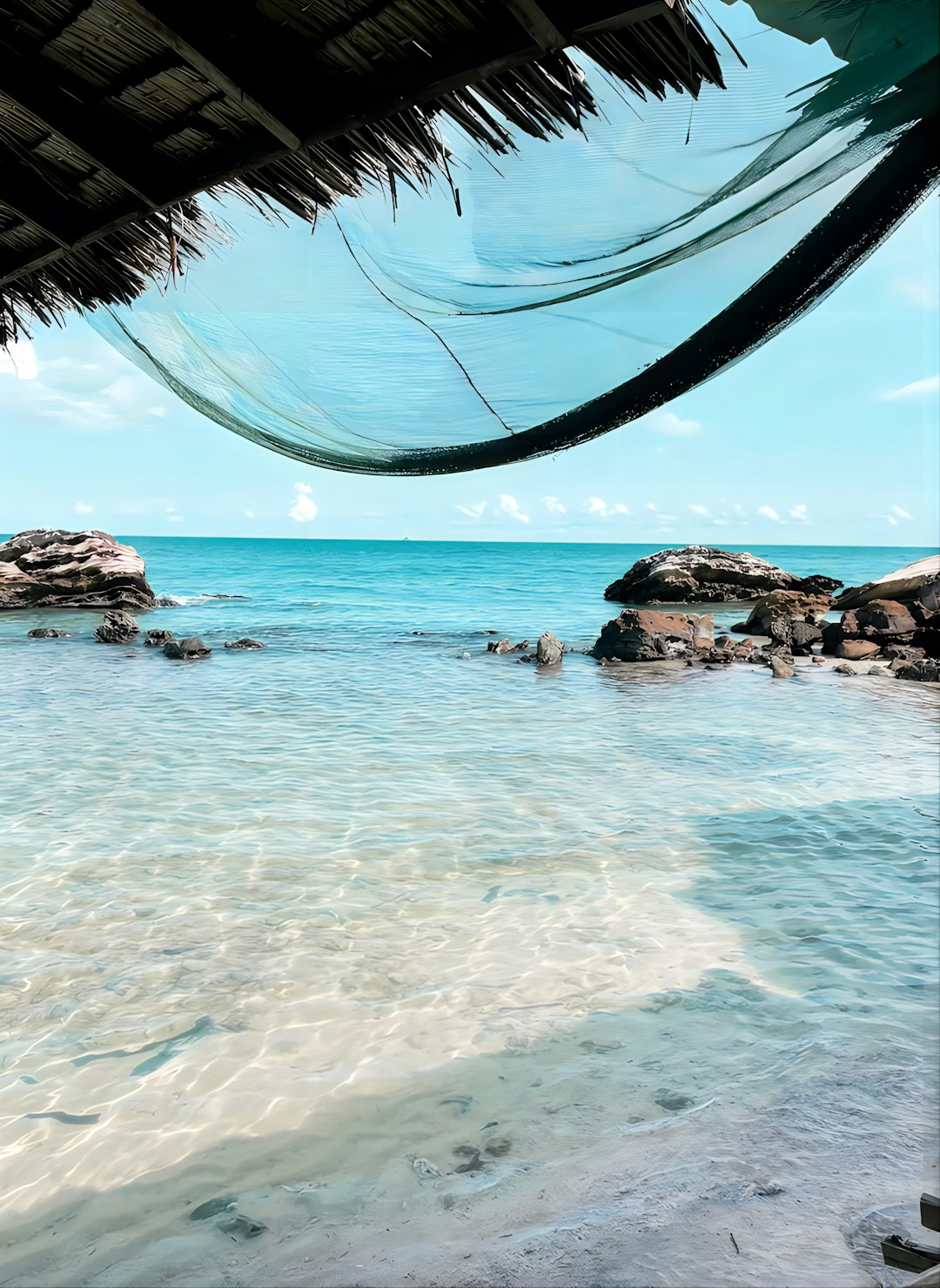 Beach with rocky outcrops and clear water in Thailand