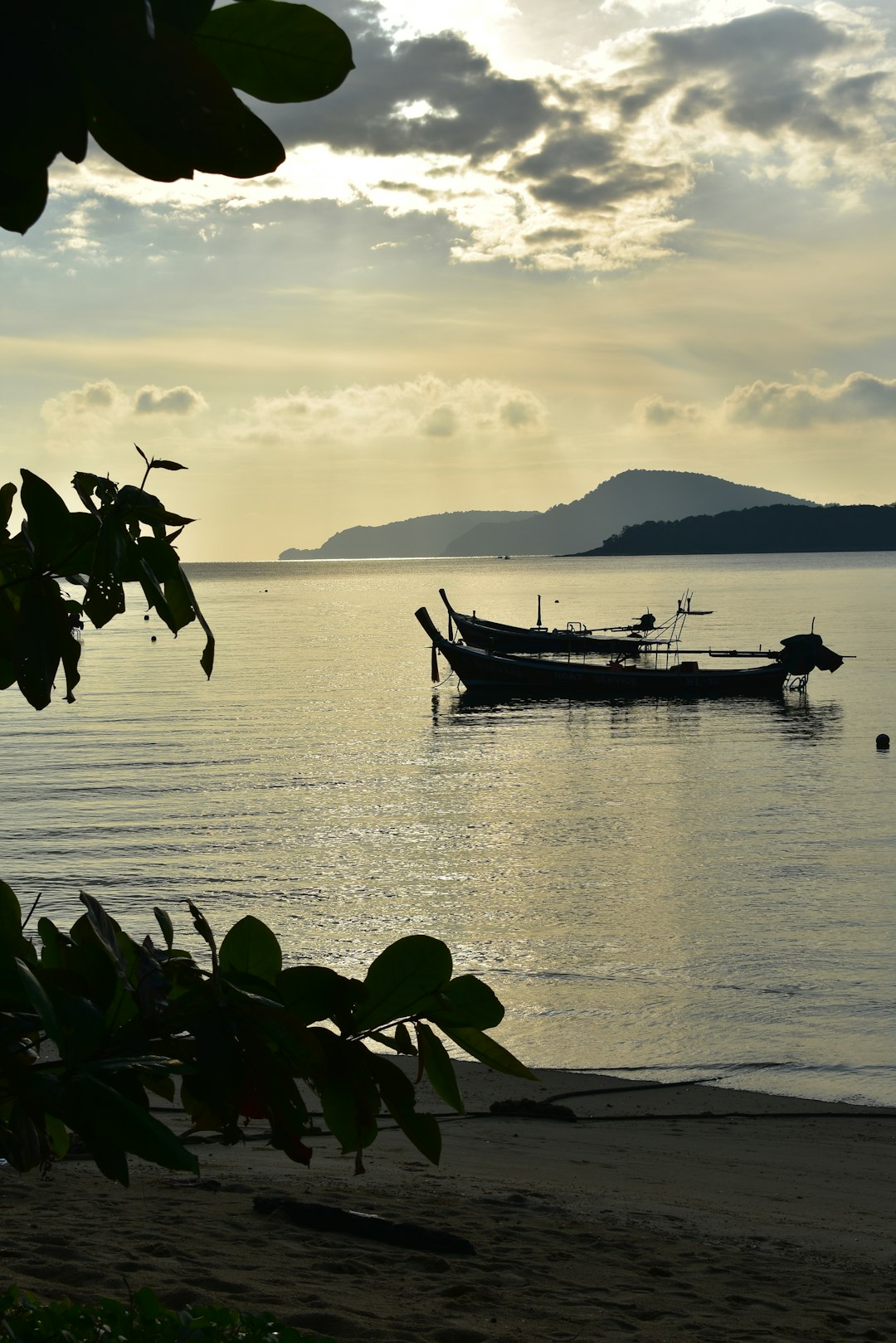 Wooden boat resting on a beach next to the ocean