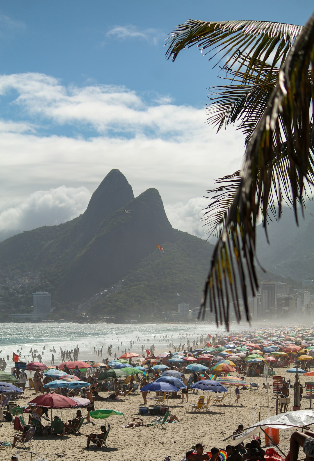 Crowded beach with a mountain rising in the background