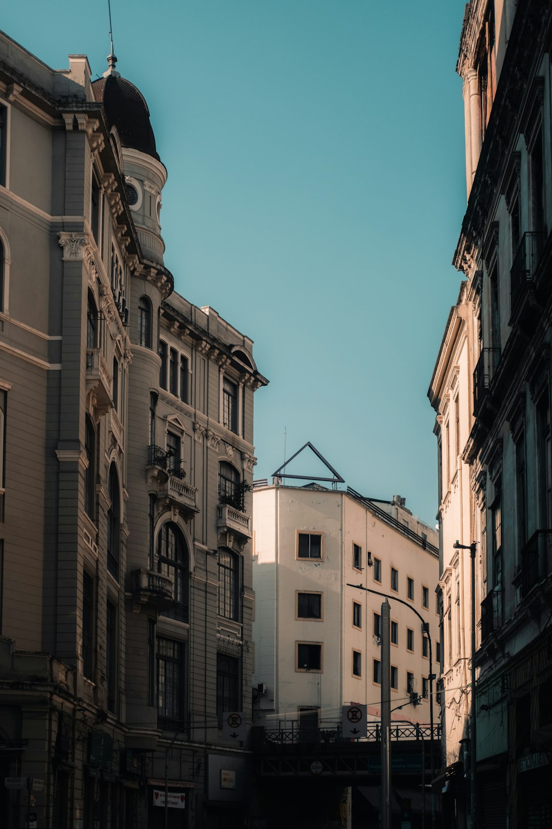 Buildings lining a street under a bright blue sky
