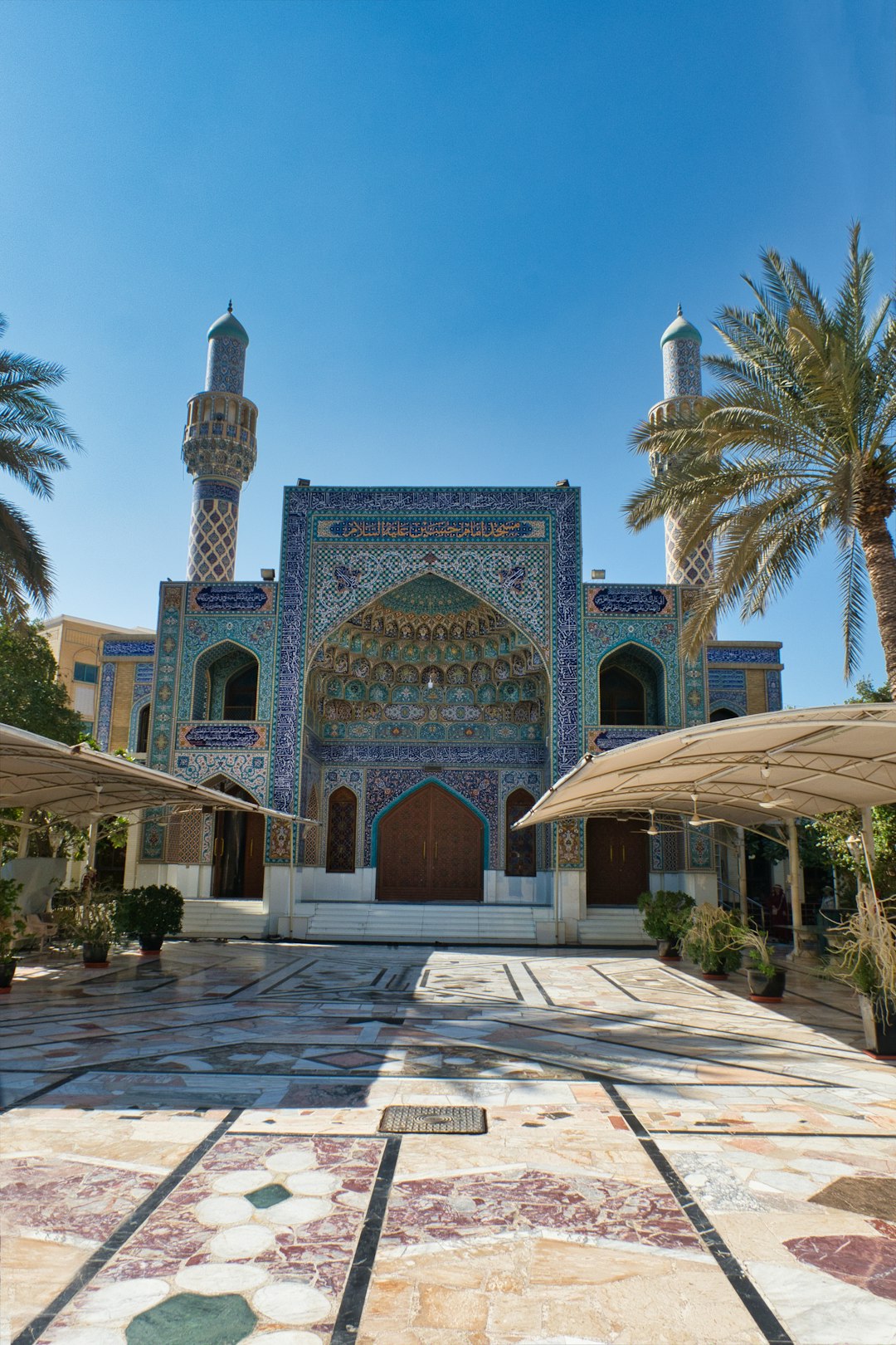 ornate mosque with two minarets and palm trees in Abu Dhabi