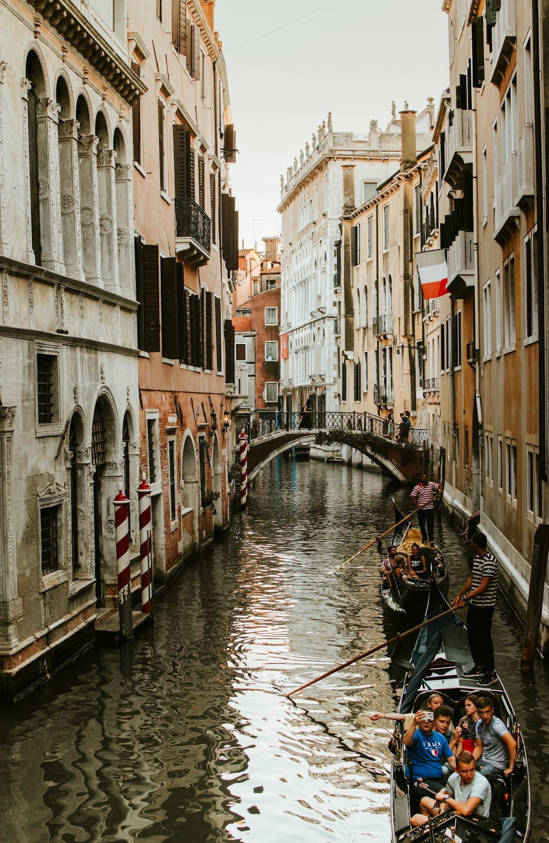 Small boats gliding along a canal between buildings in Venice
