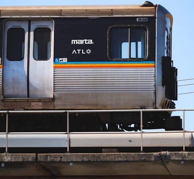 MARTA train on an elevated track in Atlanta with the ATL logo on the silver carriage