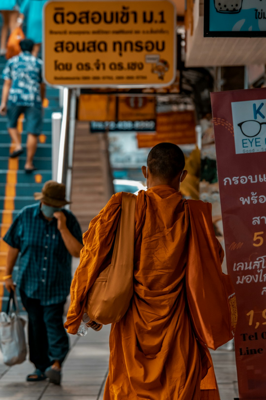 Man walking past a street sign in a Southeast Asian town