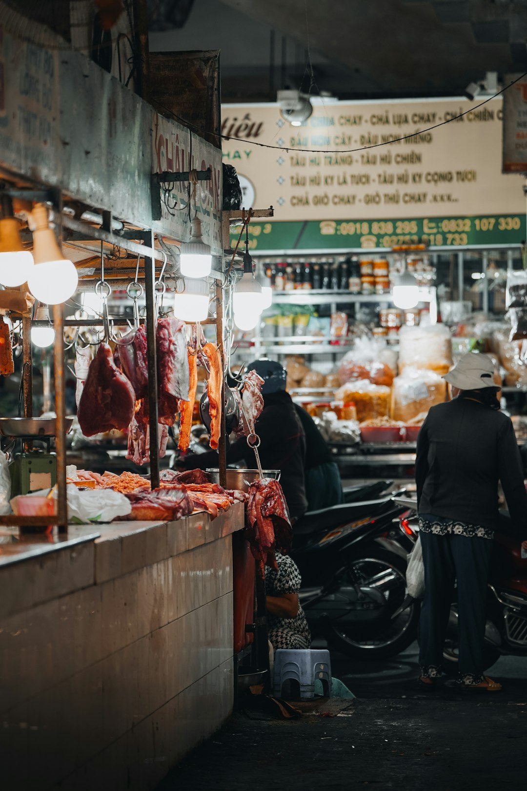 Meat hanging for sale in a bustling market stall