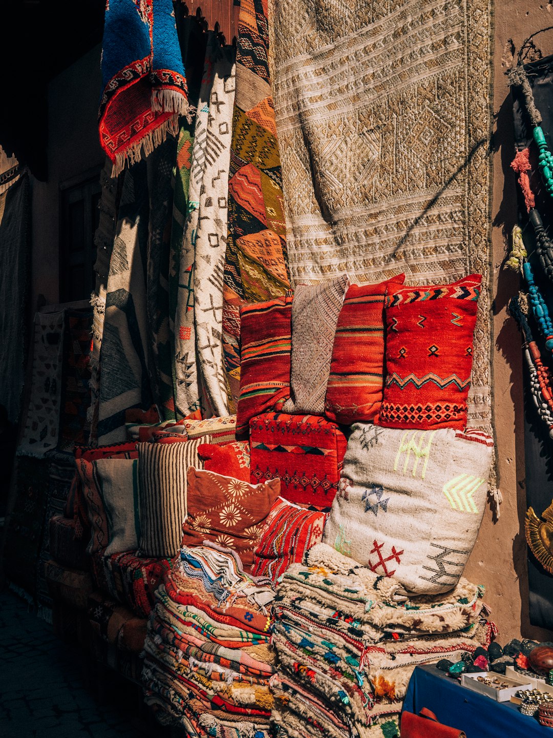 colorful textiles and cushions displayed at a Moroccan market stall