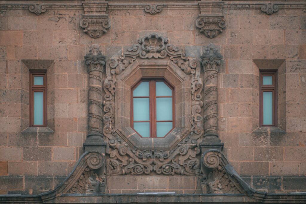Ornate window on a stone building in Mexico, relevant to choosing a sim card mexico option
