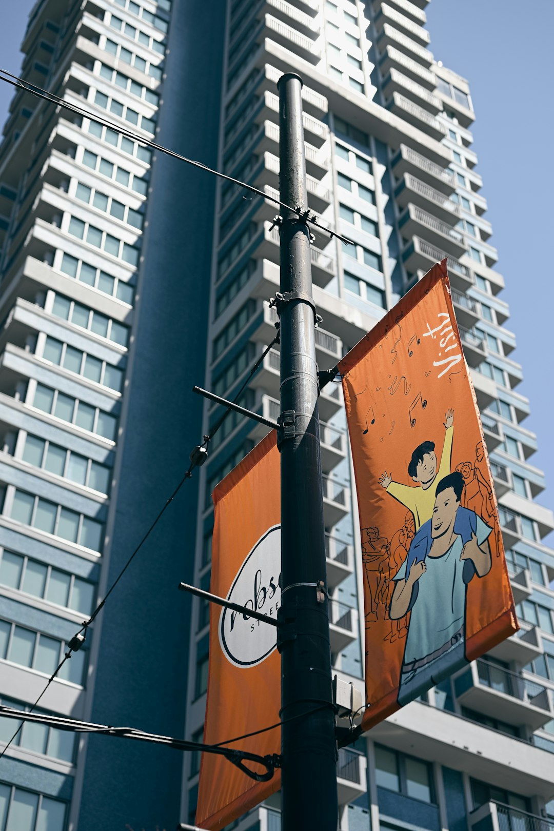 orange banners hanging from a pole in a Canadian city