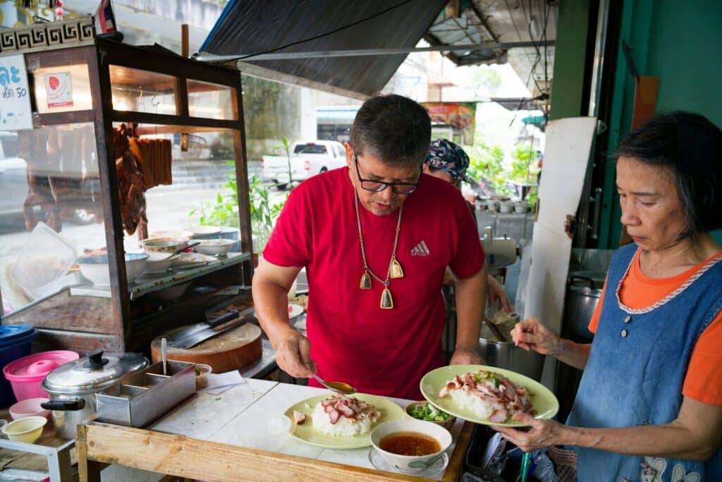 Vendors preparing food at a street food stall