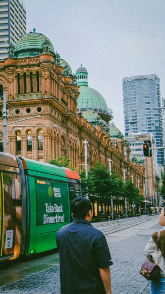 Tram passing a historic building in an Australian city