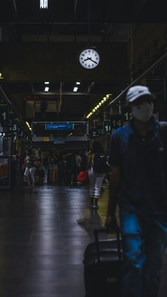 Traveler walking through a train station with luggage
